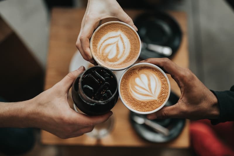 Latte art in two cups on a wood table